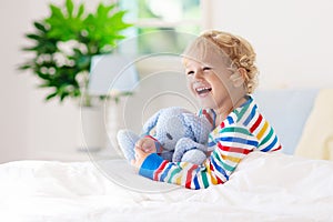 Child playing in bed. Kids room. Baby boy at home