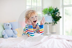 Child playing in bed. Kids room. Baby boy at home