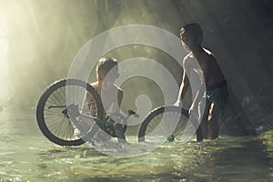 Child playing with bicycle in the creek