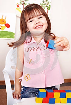 Child playing block in play room.