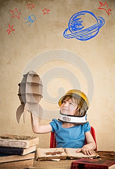 Child playing with cardboard toy rocket