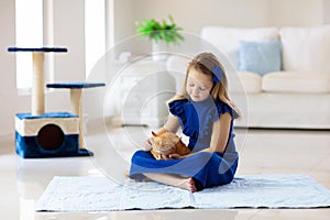 Child playing with cat at home. Kids and pets