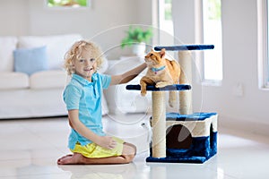 Child playing with cat at home. Kids and pets