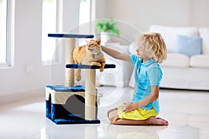 Child playing with cat at home. Kids and pets