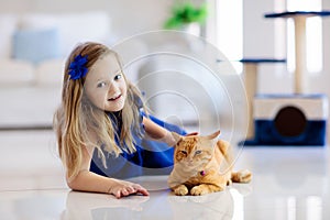 Child playing with cat at home. Kids and pets