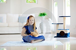 Child playing with cat at home. Kids and pets