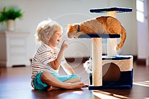 Child playing with cat at home. Kids and pets