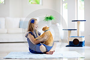 Child playing with cat at home. Kids and pets