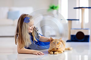 Child playing with cat at home. Kids and pets