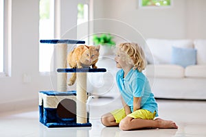 Child playing with cat at home. Kids and pets