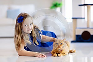 Child playing with cat at home. Kids and pets