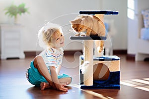 Child playing with cat at home. Kids and pets