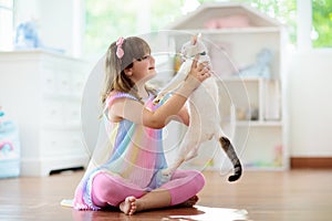 Child playing with cat at home. Kids and pets