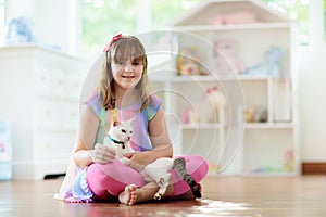 Child playing with cat at home. Kids and pets