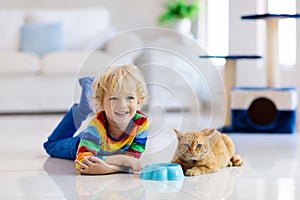 Child playing with cat at home. Kids and pets