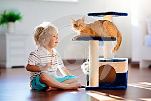 Child playing with cat at home. Kids and pets photo