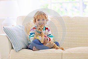 Child playing with cat. Kid and kitten