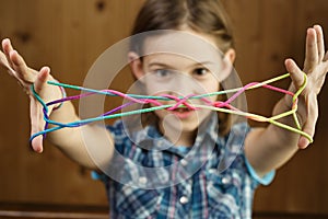 Child playing classic string game, creating shapes