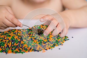 Child playing with colored rice.