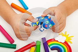 Child playing with colorful clay - closeup on hands