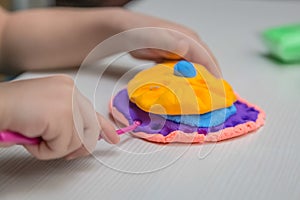 Child playing with colorful clay making figures.