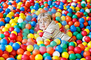 Child playing at colorful plastic balls playground