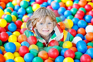 Child playing at colorful plastic balls playground