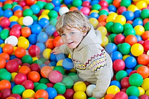 Child playing at colorful plastic balls playground