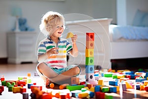 Child playing with colorful toy blocks. Kids play