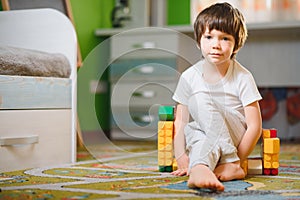 Child playing with colorful toy blocks. Little boy building tower at home or day care. Educational toys for young