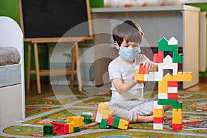 Child playing with colorful toy blocks. Little boy building tower at home or day care. Educational toys for young children.