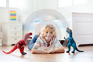 Child playing with toy dinosaurs. Kids toys