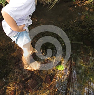 Child playing in a creek