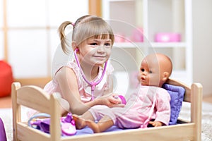 Child Playing Doctor with doll Toy photo