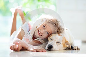 Child playing with dog. Kid and puppy at home