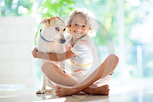 Child playing with dog. Kid and puppy at home