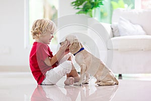 Child playing with dog. Kids play with puppy photo