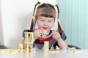Child playing with dominoes at table