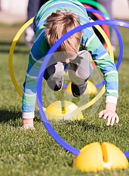 Child playing in a exercising circle - tunnel tube, crawling through it and having fun