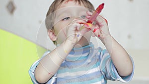 Child is playing with a felt-tip pen. The face of a happy child, painted with a felt-tip pen. A dirty child laughs and