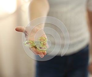 Child playing with fidget spinner closeup indoors showing it on hand to camera