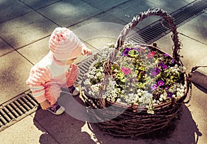 A child is playing in a flower bed