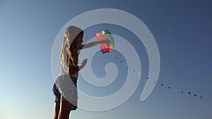 Child playing flying kite, kid on beach at sunset, happy little girl, coastline