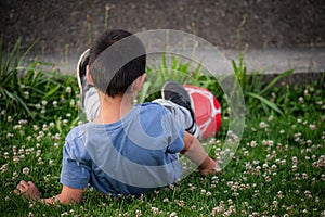 Child playing football. One Asian boy falling down