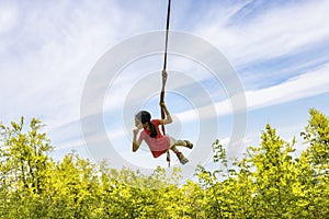 Child playing in the forest, with homemade swing