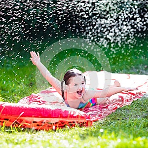 Child playing with garden water slide