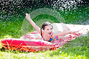 Child playing with garden water slide