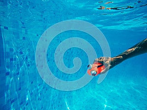 Child playing with generic rubber fish toy in swimming pool