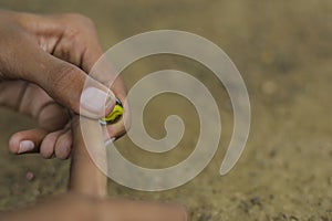 A child playing with glass marbles which is an old Indian village game. Glass Marbles are also called as Kancha in Hindi Language