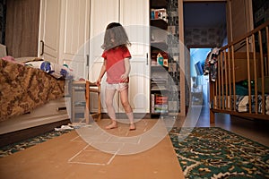 Child playing hopscotch inside at her home healthy body lifestyle concept, side view. what to do in quarantine. street